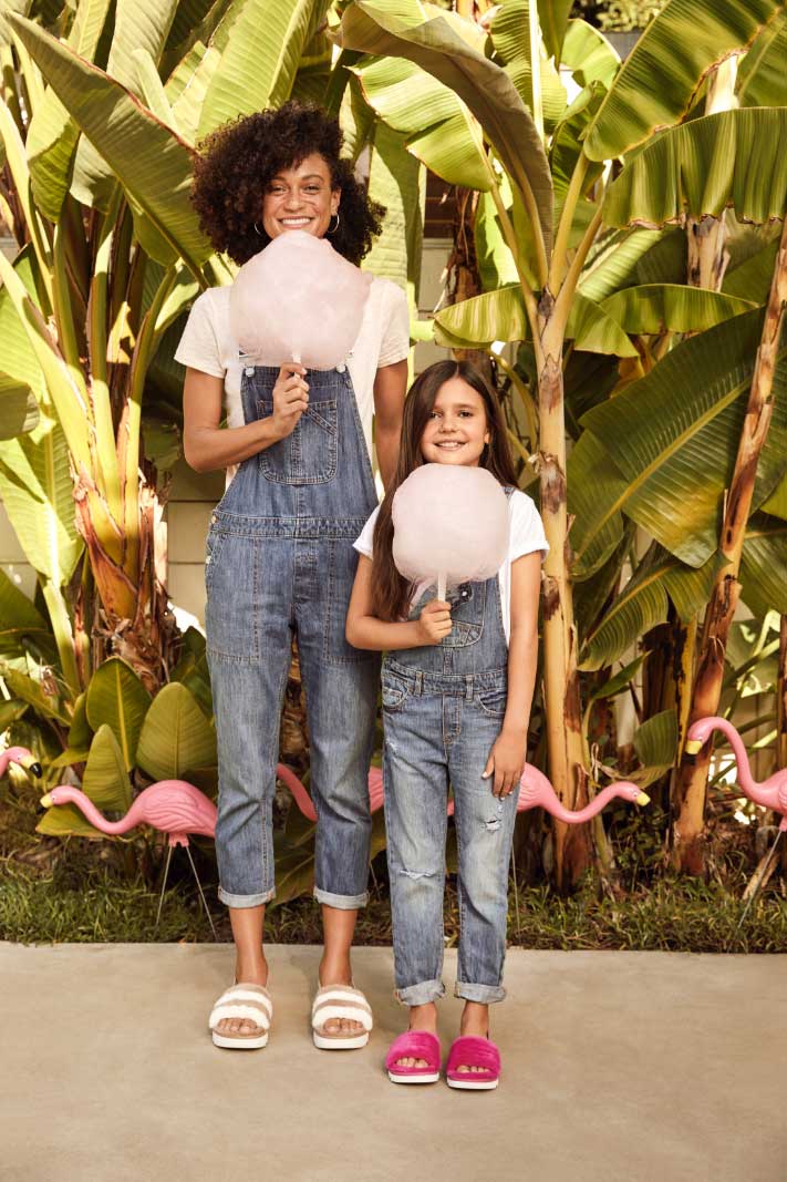 Woman and girl in Koolaburra slippers, eeating cotton candy.