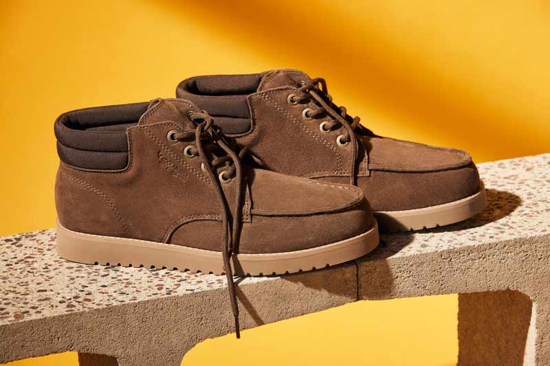 A pair of masculine Koolaburra shoes displayed on a bright backdrop.